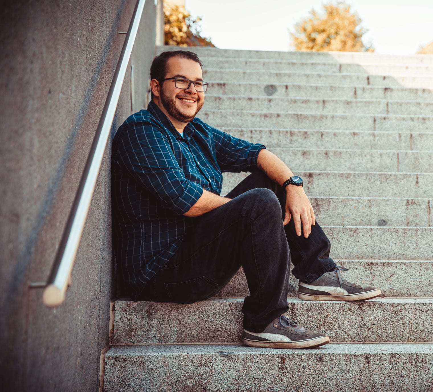 Dominic Schlatter sitzt auf den Stiegen bei der Stadthalle